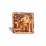 A medieval encaustic tile c.15th century, decorated in cream slip with a figure seated with legs