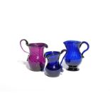 Three coloured glass cream jugs c.1780-1800, one amethyst and spiral-moulded with a folded rim and