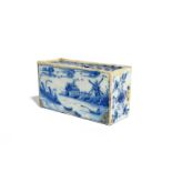 A delftware flower brick c.1740, the rectangular form painted to the longer sides with a figure in a