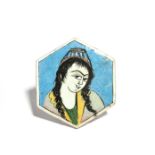 A Qajar hexagonal tile mid 19th century, painted with a head and shoulders portrait of a girl with