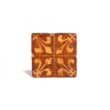 A medieval encaustic tile c.14th/15th century, decorated in cream slip with a fleur de lys to each