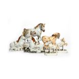 Two pairs of Delft horses mid 18th century, the small pair modelled jumping over fences, saddled and