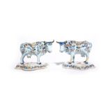 A pair of Delft cows probably 19th century, each standing four square on a shaped base with head