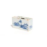 A delftware flower brick c.1750-60, each long side painted in blue with large low huts beneath
