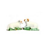 A pair of Yorkshire pearlware sheep c.1800, recumbent and modelled with heads slightly turned,