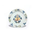 A delftware plate c.1740-50, simply decorated in green, blue, yellow, red and manganese with a