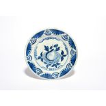 A Delft charger c.1640, painted with blue with an arrangement of fruit featuring a large pear, the