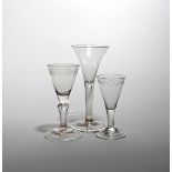 Three wine glasses c.1730-40, one with a drawn trumpet bowl above a plain stem enclosing a long tear