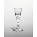 A small baluster wine glass c.1740, the rounded funnel bowl raised on a slender baluster stem with