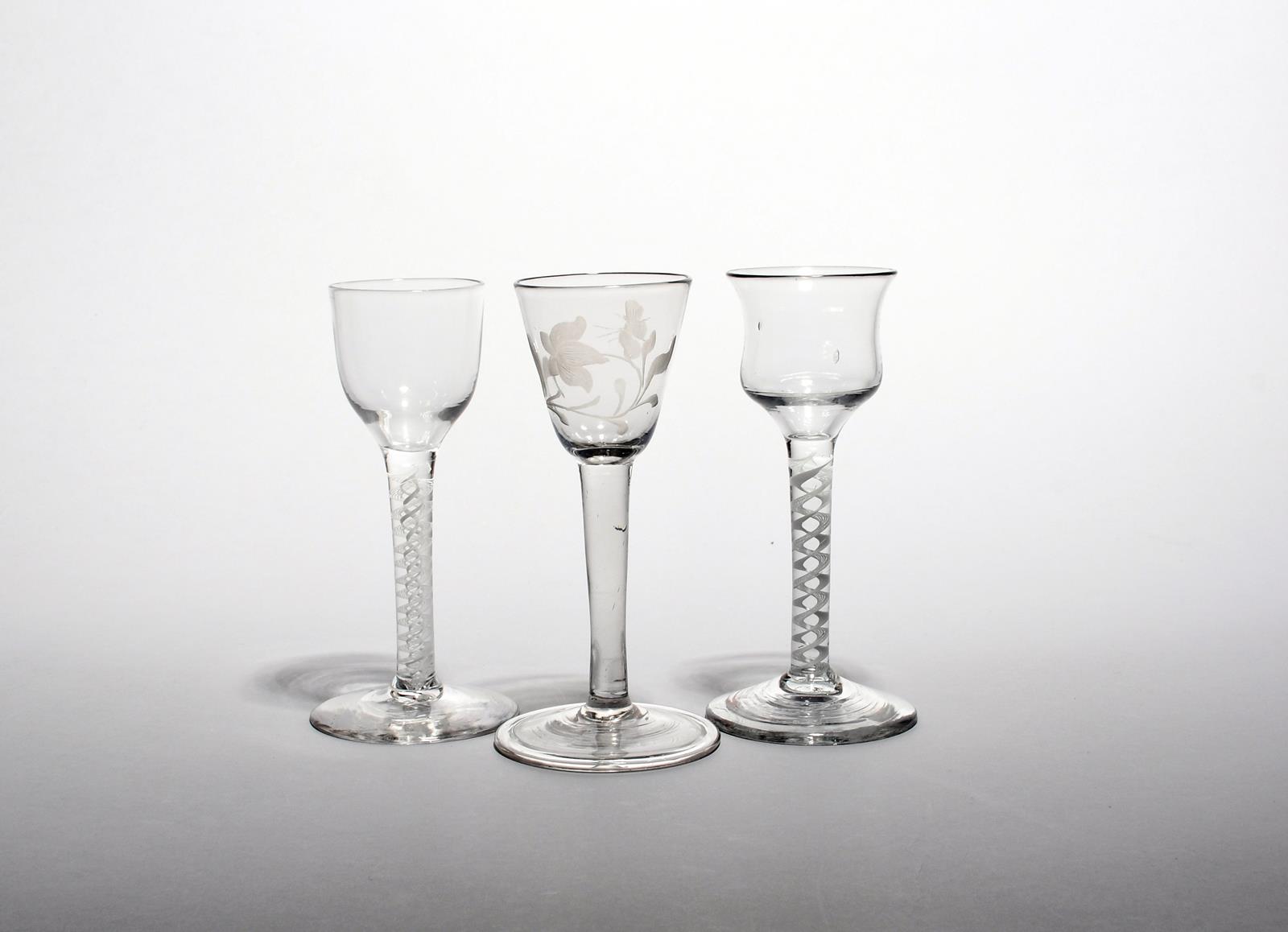 Three small wine glasses c.1760, one with a rounded funnel bowl engraved with a flower raised on a