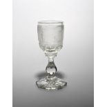 A Bohemian glass goblet dated 1845, the thick bowl deeply engraved with a continuous scene of a