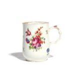 A Longton Hall mug c.1755, the slender waisted body painted with a spray of flowers including rose