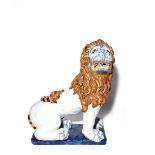 A large French faïence figure of a lion late 19th/early 20th century, perhaps Rouen, seated with