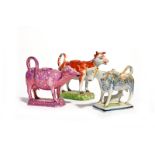 Three pearlware cow creamers and covers 19th century, one Pratt ware and sponged ion blue and ochre,