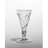 A dwarf ale glass c.1740, the drawn trumpet bowl with spiral moulding rising to a flammiform edge,