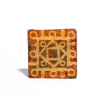 A medieval encaustic tile c.14th/15th century, decorated in cream slip with a geometric lattice