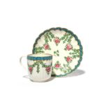 A Worcester coffee cup and saucer c.1775, the fluted forms painted with berried garlands in the