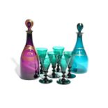Two coloured glass decanters and stoppers c.1800, one amethyst, the other green, gilded with the