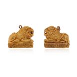 A pair of Etruscan style lion pendants, the stylised recumbent lions are sitting on a gold plinth