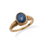 A late Victorian sapphire solitaire ring, the oval sapphire is set in yellow gold with scroll