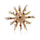 ‡ A ruby and diamond brooch by Andrew Grima, the stylised starburst set with graduated round