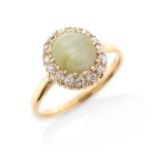 A chrysoberyl cat's eye and diamond cluster ring, the cabochon chrysoberyl set within a surround