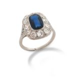 An early 20th century sapphire and diamond cluster ring, the oval-shaped sapphire is set within a