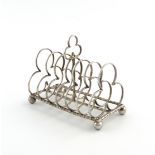 A silver seven-bar toast rack, by Nathan and Hayes, Chester 1913, trefoil shaped bars, with a