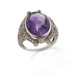 An amethyst and diamond ring, the oval-shaped amethyst is set within a surround of circular-cut