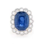 A sapphire and diamond cluster ring, the cushion-shaped sapphire weighs 15.03cts,