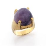 An amethyst-set gold ring, the domed cabochon amends is set in textured yellow gold, size O 1/2