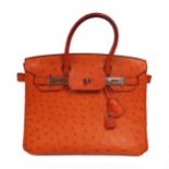 λ An orange Ostrich 'Birkin' bag by HERMÈS, orange ostrich leather, silver-tone hardware, twist lock