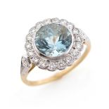 An aquamarine and diamond cluster ring, the round brilliant-cut aquamarine is set within a