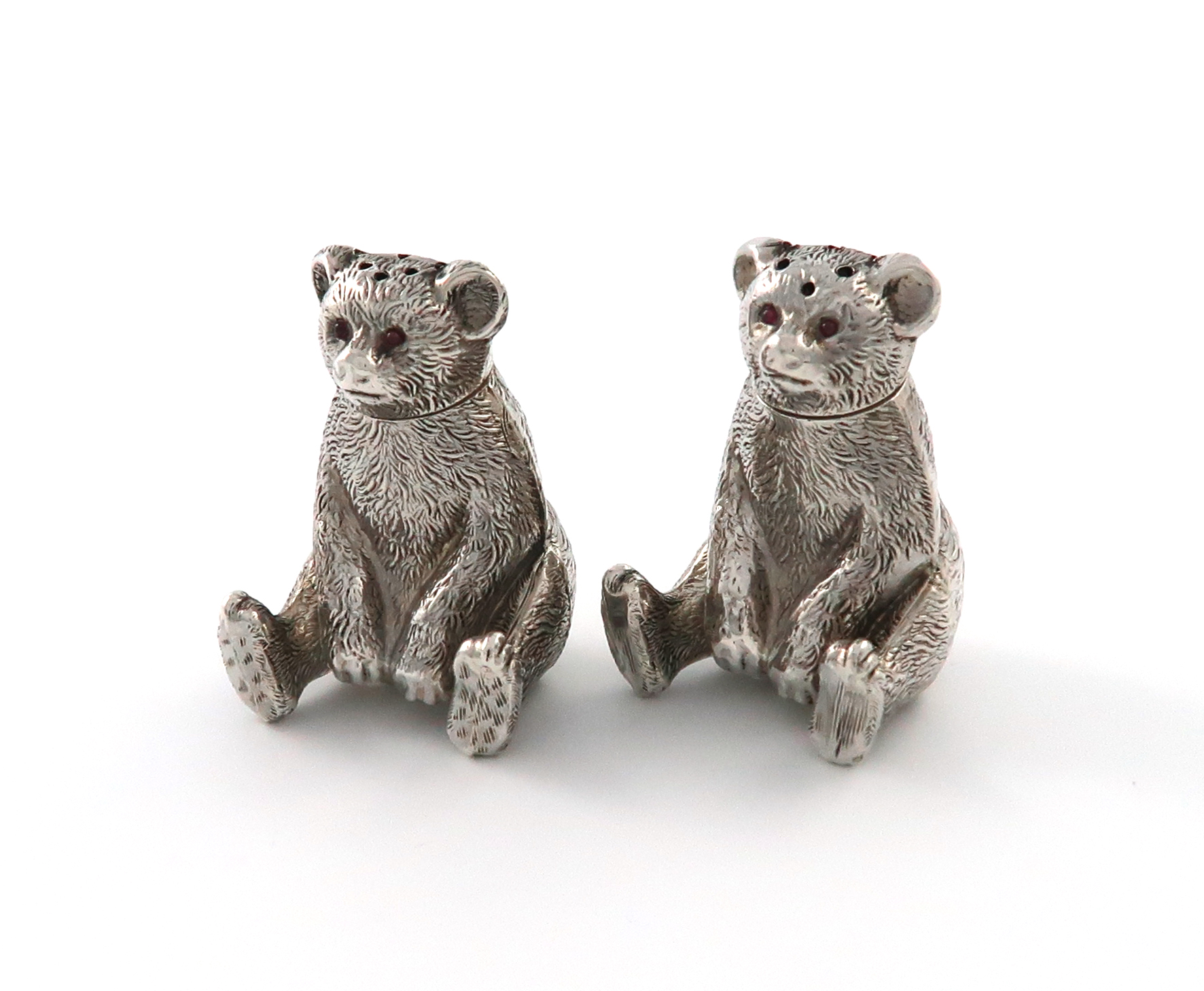 A matched pair of Edwardian novelty silver bear pepper pots, one by Henry Williamson Ltd, the