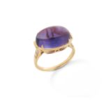 An amethyst and diamond ring, set with an amethyst cabochon, with graduated round brilliant-cut