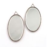 A pair of Edwardian silver mirrors, by Samuel Jacob, London 1907, plain oval form, with a hinged