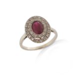 A French ruby and diamond cluster ring, the oval-shaped ruby set within a surround of rose-cut