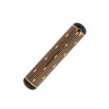 An Art Deco gold lipstick holder by Cartier, of cylindrical form, with black enamel decoration and