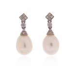 A pair of cultured pearl and diamond drop earrings, the cultured pearl drops suspend from circular-