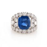 A sapphire and diamond cluster ring, the cushion-shaped sapphire weighs 5.15cts, the openwork ring