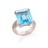 A blue topaz and diamond ring, the step-cut blue topaz set with round brilliant-cut shoulder