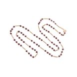 A garnet bead-mounted gold necklace, the garnet beads alternately-set with spring-form fancy gold