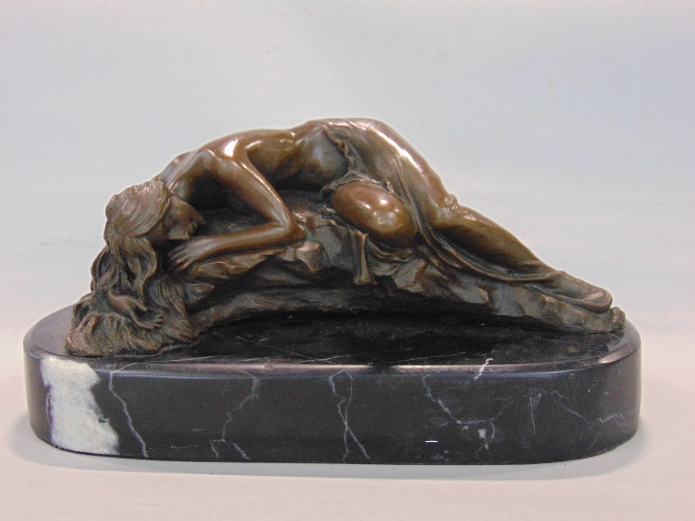 Cast bronze figure of a reclining nude on a naturalistic base, signed Milo, upon a black marble