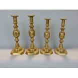 Two pairs of graduated brass candlesticks with King and Queen diamond pattern, the largest 32cm high