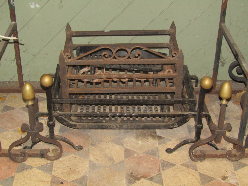 A cast iron fire basket of rectangular form and loose andirons, with swan necks and brass ball