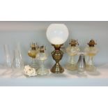 A collection of four pressed glass oil lamps, together with an opaline glass shade, various flues