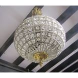 A hanging melon shaped ceiling light with open wirework frame with repeating facets hung from a