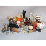 A collection of ceramic models of cats including a black glazed humorous example, together with an