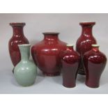 A collection of oriental vases with Sang De Boeuf glazed finish comprising a pair of baluster shaped