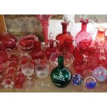 A large collection of mainly cranberry glass to include decanter jugs, beakers, goblets, vases,